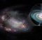 Концепция художника о карликовой галактике, ее форма искажена, скорее всего, прошлым взаимодействием с другой галактикой, и массивной черной дырой на ее окраине (отступление). Черная дыра притягивает материал, который образует вращающийся диск и генерирует струи материала, движущиеся наружу.